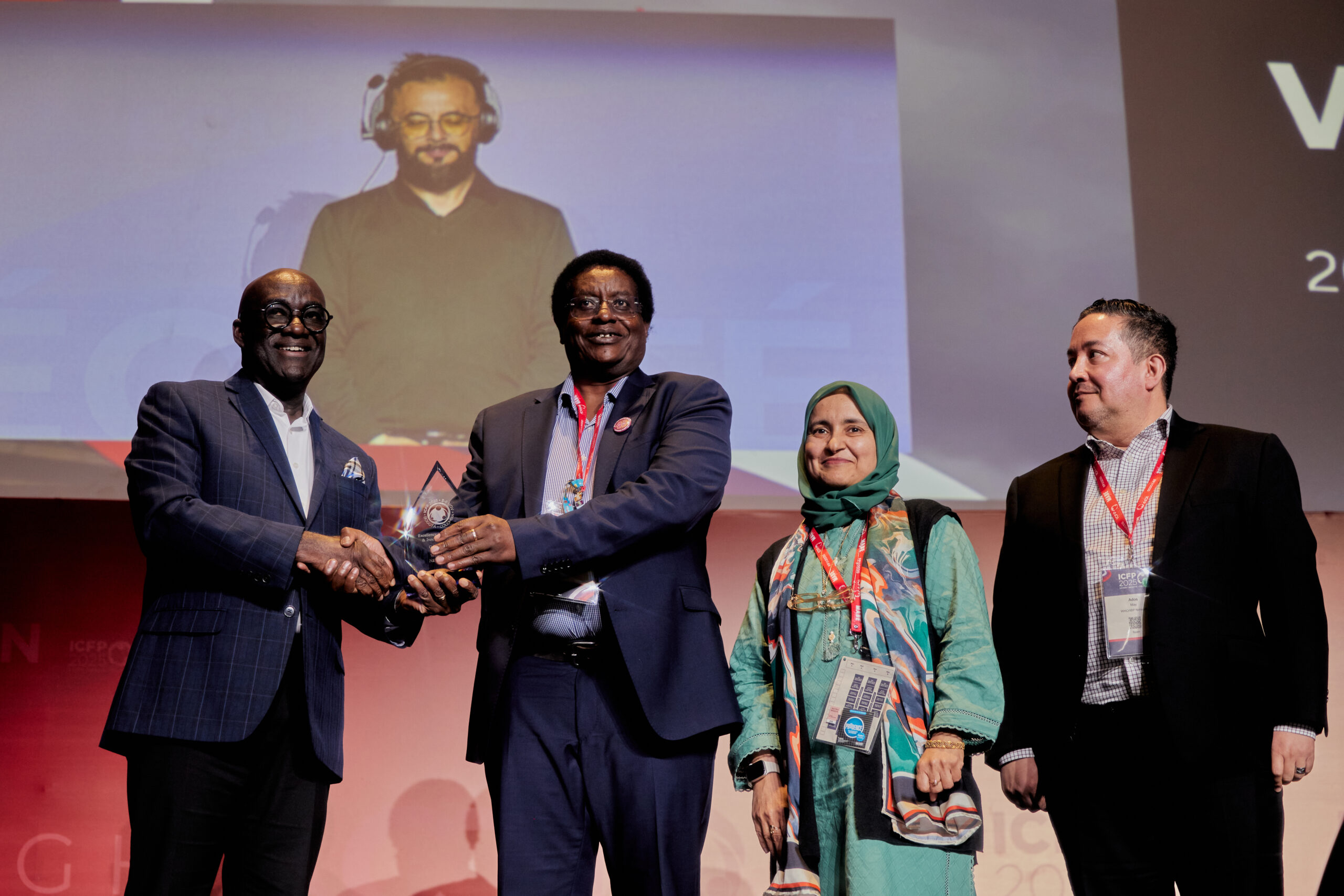 Three individuals accepting an award on a stage