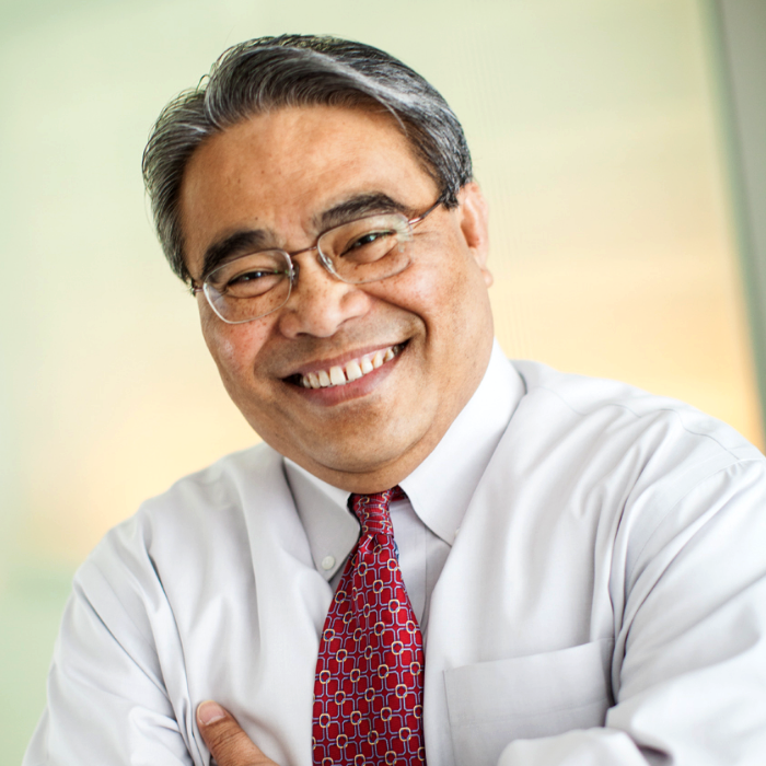 Headshot of a man in white shirt with a red tie and glasses