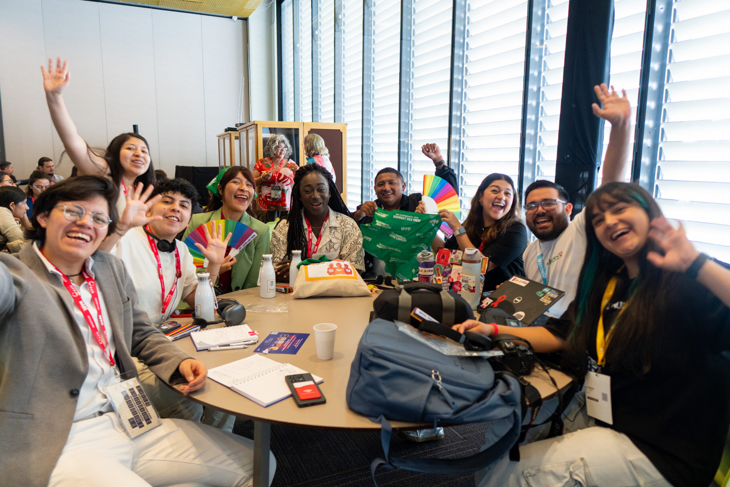 Young people sitting around a table and waving