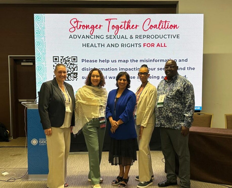 Five people standing in front of an event sign